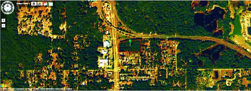 This is an aerial map showing a vacant lot outlined in red near a highway — N VOLUSIA AVENUE, ORANGE CITY, FL