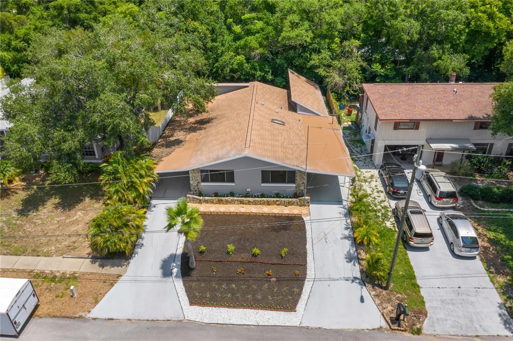 An aerial view of a single-story house with a brown roof, carport, and landscaped front yard — 1435 WEGMANN DRIVE, TARPON SPRINGS, FL