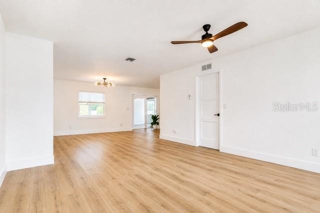 A bright, empty room features light wood-look flooring, white walls, and a ceiling fan — 5140 TREND ROAD, WEST MELBOURNE, FL