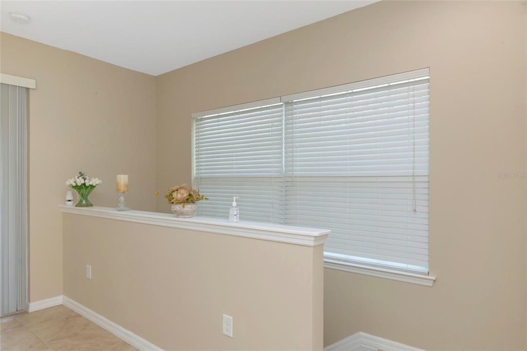 A half-wall separates a tiled room from a window with white horizontal blinds — 4296 EXPEDITION WAY UNIT 104, OSPREY, FL