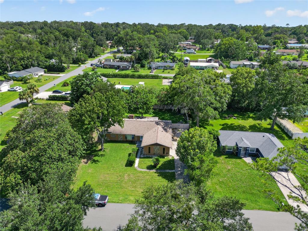 An aerial view shows two single-story houses surrounded by large trees and green lawns — 3216 SE 34TH STREET, OCALA, FL