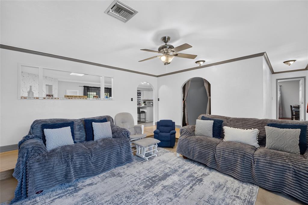 A living room features two grey textured sofas, a blue recliner, and a large area rug — 3216 SE 34TH STREET, OCALA, FL