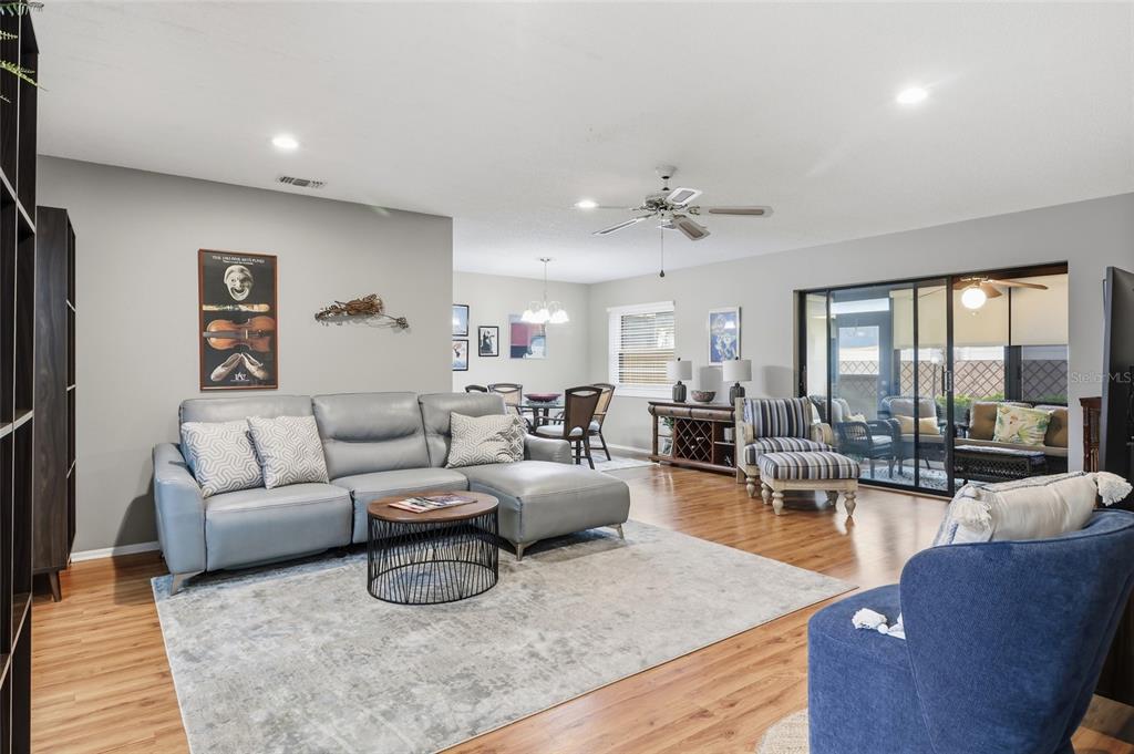 A living room with a gray sectional sofa, area rug, and sliding doors to a patio — 3191 GLEN ELYN BOULEVARD UNIT 4, SARASOTA, FL