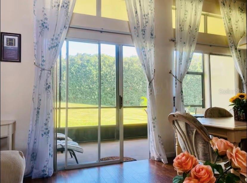 A dining area features sliding glass doors opening to a screened patio and green lawn — 3161 TAMARIND CIRCLE, KISSIMMEE, FL