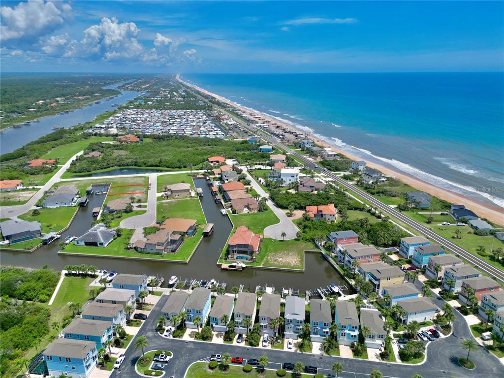 An aerial view of a coastal neighborhood featuring houses, canals, and a nearby beach — 90 HIDDEN COVE, BEVERLY BEACH, FL