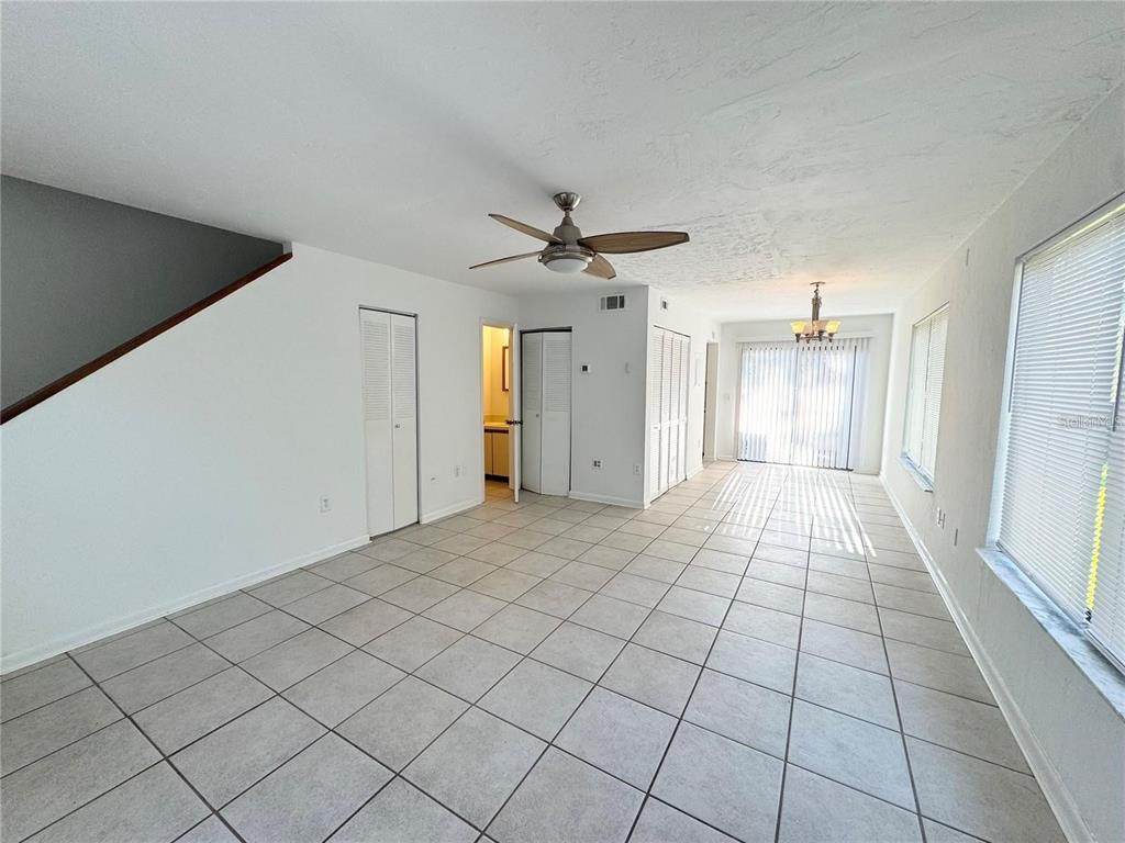 A bright, tiled living and dining area features a ceiling fan and sliding glass doors — 2300 SW 43RD STREET UNIT M4, GAINESVILLE, FL