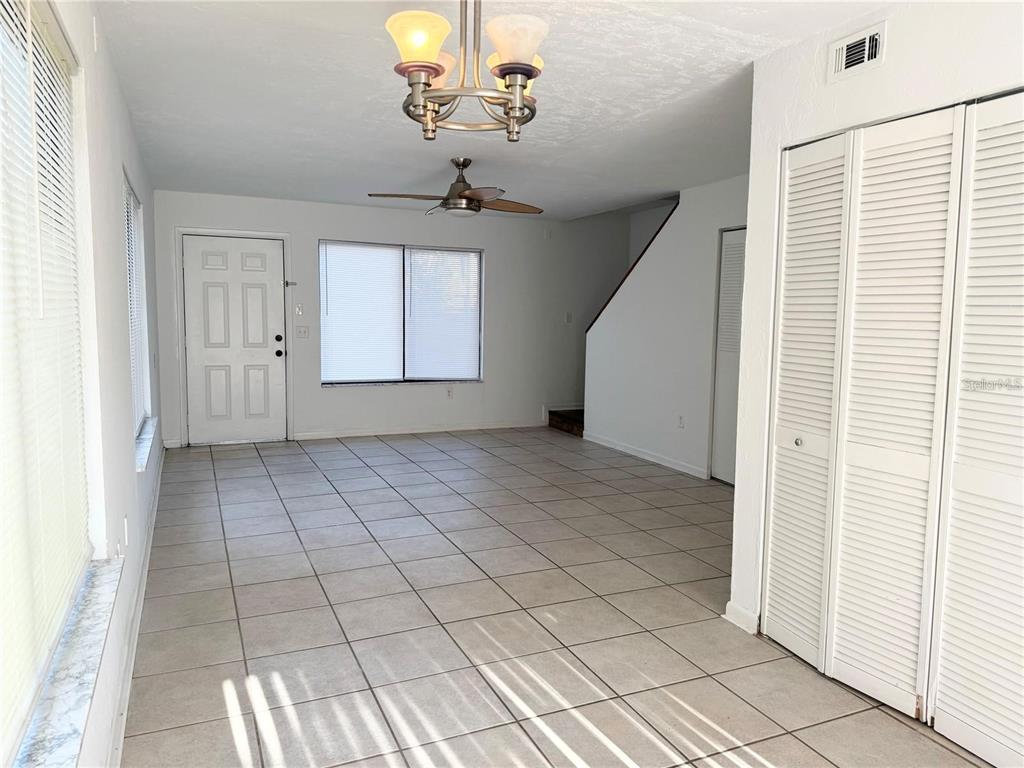 An empty room with light tile flooring, a ceiling fan, and white louvered closet doors — 2300 SW 43RD STREET UNIT M4, GAINESVILLE, FL