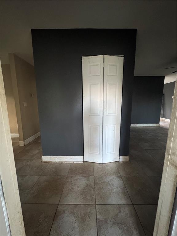 A dark-painted wall features a white bi-fold closet door above light-colored tiled flooring — 4005 CASCADE LANE, LABELLE, FL