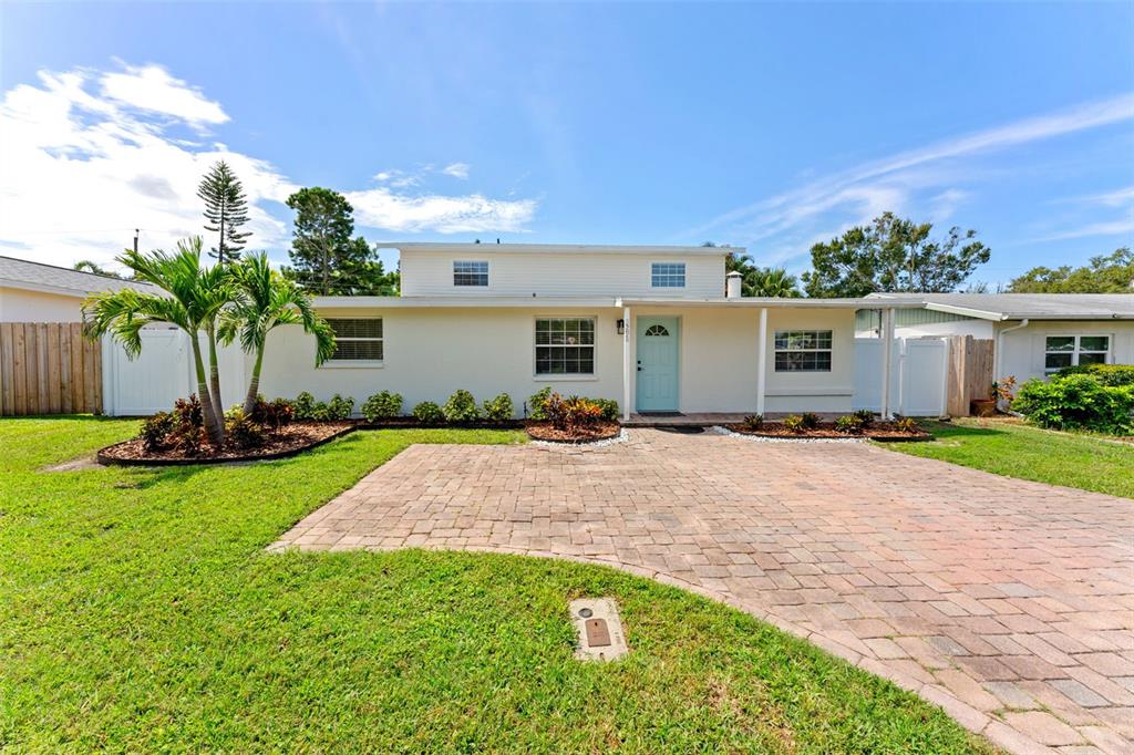 A single-story house with a light-colored exterior, a paved driveway, and a front lawn — 3298 21ST AVENUE SW, LARGO, FL
