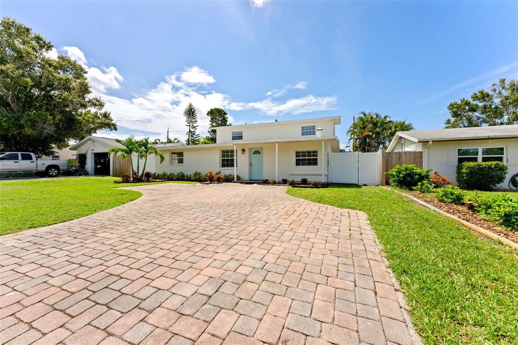 A single-story house with a light blue front door and a paved brick driveway — 3298 21ST AVENUE SW, LARGO, FL