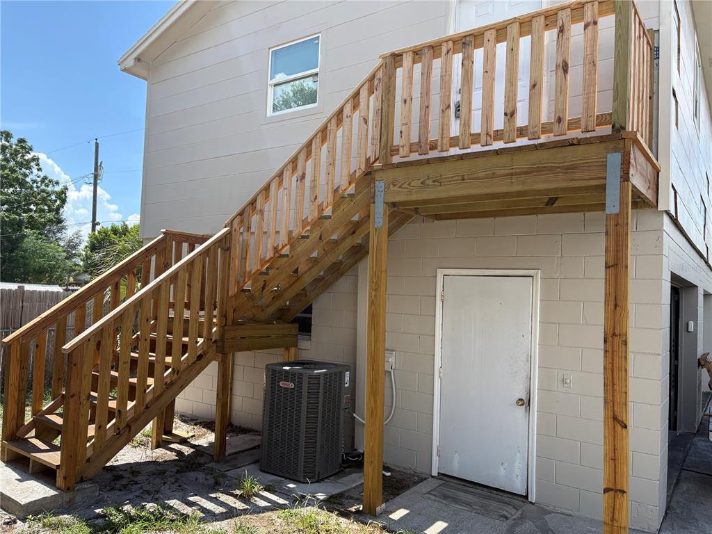 An exterior view of a house featuring a wooden staircase leading to an upper deck — 1100 JAMELA DRIVE UNIT B, OCOEE, FL