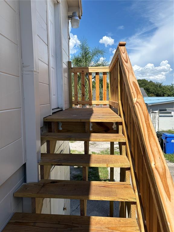 An exterior view of a wooden staircase leading to a doorway on the side of a house — 1100 JAMELA DRIVE UNIT B, OCOEE, FL