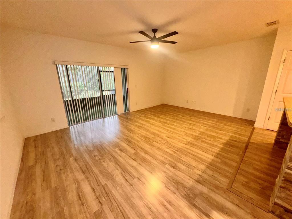 An interior entryway features a white six-panel door, light wood-look flooring, and white walls — 2896 TANZANITE TERRACE, KISSIMMEE, FL