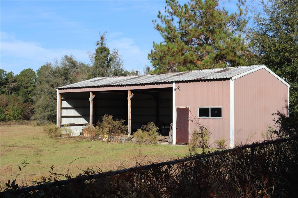 A metal-sided barn with an open bay and a small enclosed storage area — 8340 SW 35TH AVENUE, OCALA, FL