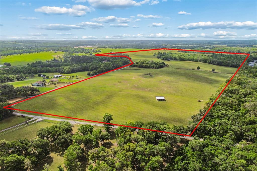 An aerial view shows a large, open grassy field outlined in red — BAYHEAD ROAD Lot 6, DADE CITY, FL