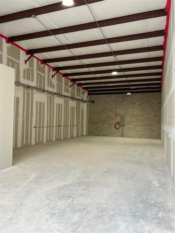 An unfinished warehouse space features exposed steel beams, concrete block walls, and drywall panels — 1450 HAMLIN AVENUE, ST CLOUD, FL