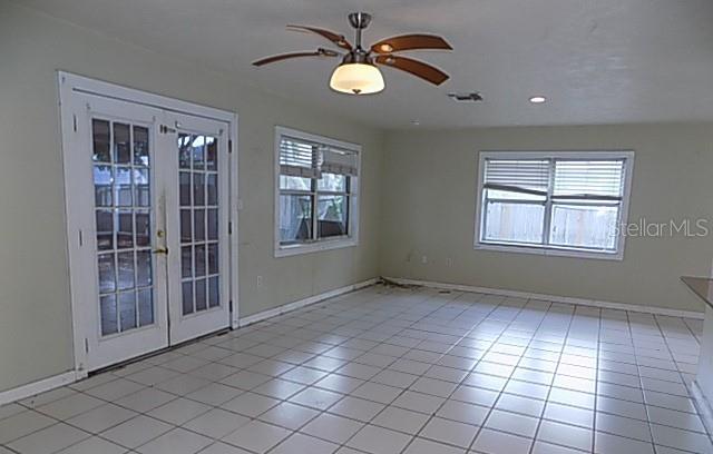 A room with white tile flooring, a ceiling fan, French doors, and two windows — 3408 17TH AVENUE W, BRADENTON, FL