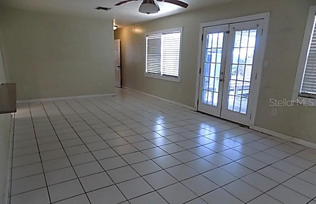 A room with white tiled floors, a ceiling fan, and glass French doors — 3408 17TH AVENUE W, BRADENTON, FL