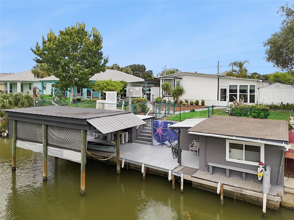 A boat trailer sits on a concrete driveway in front of a house with palm trees — 109 DOUGLAS STREET, EDGEWATER, FL
