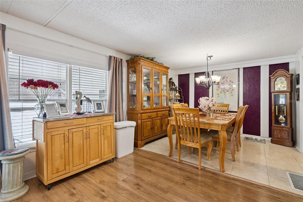 A dining room features a wooden table, a hutch, a grandfather clock, and purple accent walls — 109 DOUGLAS STREET, EDGEWATER, FL