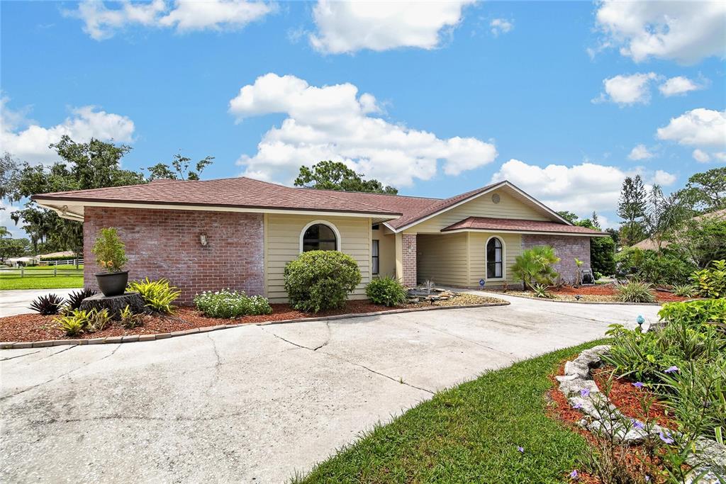 A single-story house with a brick and siding exterior features a concrete driveway and landscaping — 2814 HAMMOCK DRIVE, PLANT CITY, FL