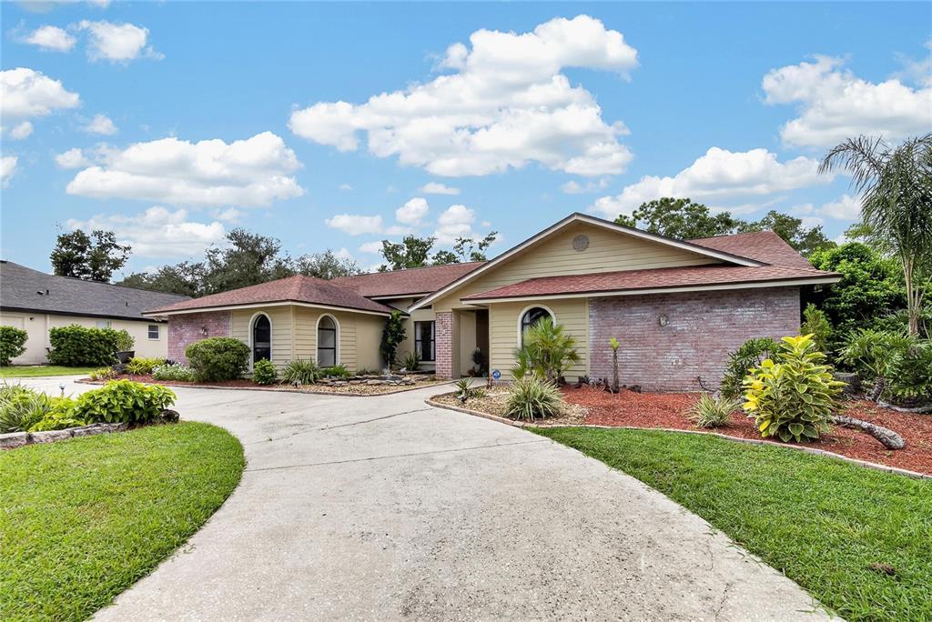 A single-story house with a brick and siding exterior, arched windows, and a concrete driveway — 2814 HAMMOCK DRIVE, PLANT CITY, FL