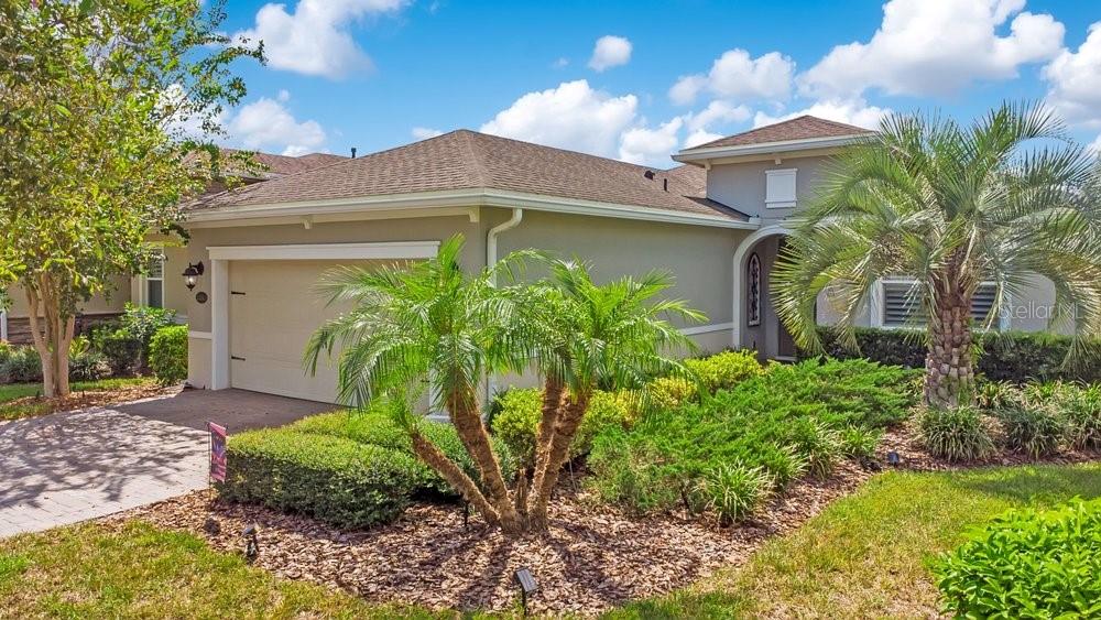 A single-story house with a beige stucco exterior, a two-car garage, and front yard landscaping — 1314 EGGLESTON DRIVE, DELAND, FL