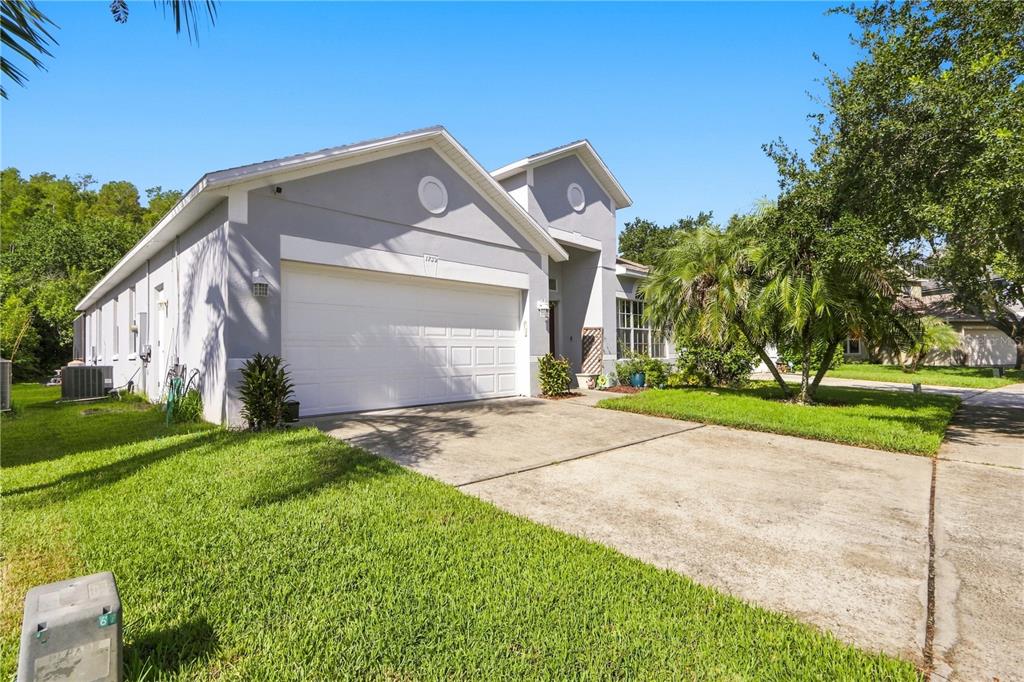 A single-story house with a white garage door, gray siding, and a concrete driveway — 1732 NESTLEWOOD TRAIL, ORLANDO, FL