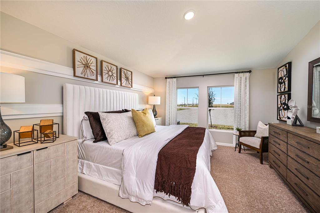 A bedroom features a white upholstered headboard, a brown throw blanket, and two large windows — 4156 RIVER BEACON BOULEVARD, DAVENPORT, FL
