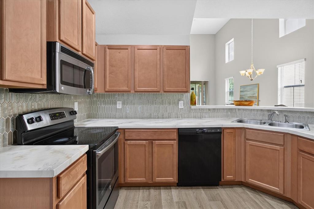 A kitchen with wood cabinets, stainless steel appliances, and a light-colored countertop — 2169 BROADWAY VIEW AVENUE, BRANDON, FL