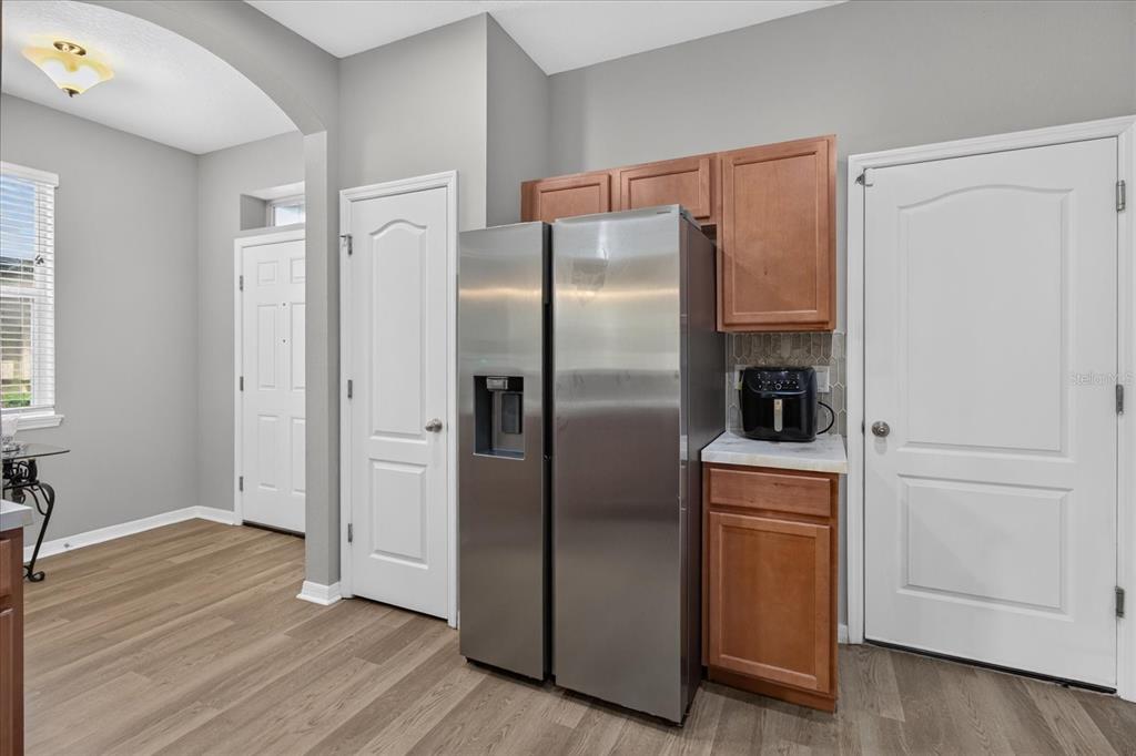 A kitchen features stainless steel appliances, wood cabinets, and light gray walls — 2169 BROADWAY VIEW AVENUE, BRANDON, FL