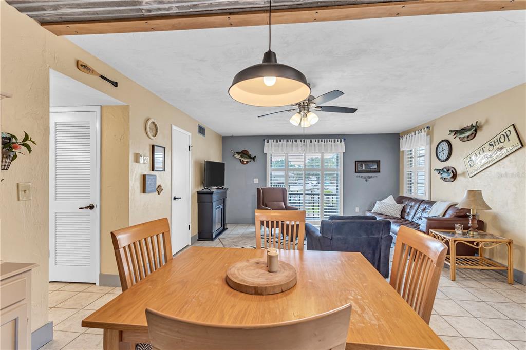 A dining area with a wooden table opens into a living room with a sofa — 1640 JUNO TRAIL UNIT 205C, ASTOR, FL