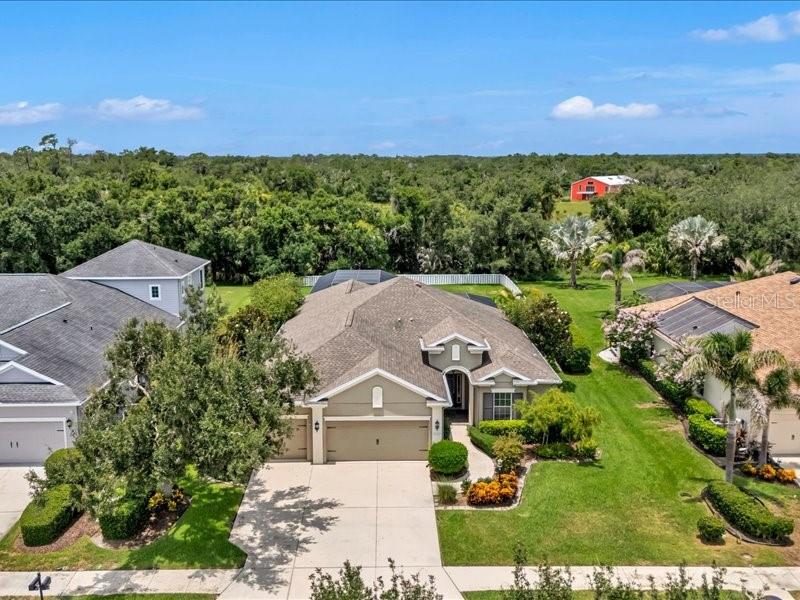 A screened-in swimming pool with a stone paver deck and white lounge chairs — 1436 HICKORY VIEW CIRCLE, PARRISH, FL