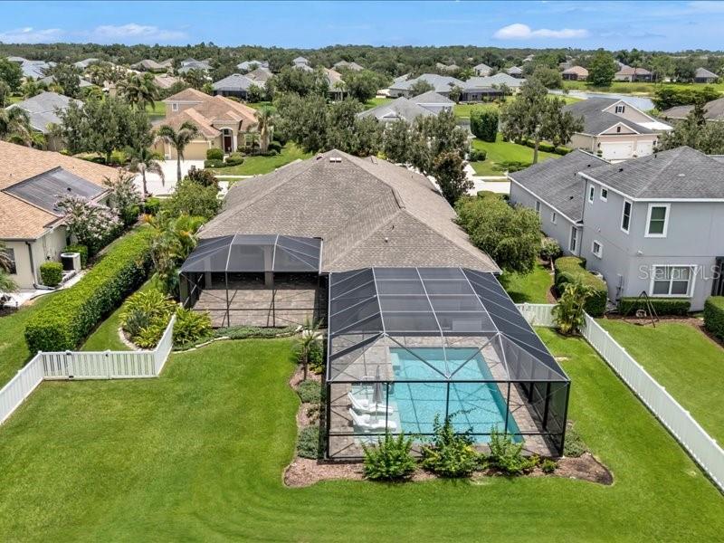 A covered patio with a wood-plank ceiling, ceiling fans, and pavers overlooks a screened pool — 1436 HICKORY VIEW CIRCLE, PARRISH, FL