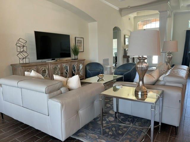A living room features light-colored leather sofas, a television console, and a glass-topped side table — 5528 ARNIE LOOP, LAKEWOOD RANCH, FL