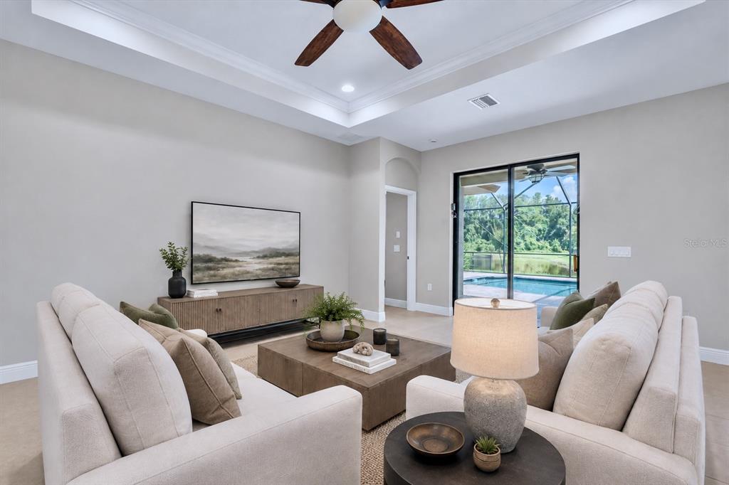 A living room features two beige sofas, a wooden coffee table, and a sliding glass door — 8454 MAY PORT COURT, LAND O LAKES, FL
