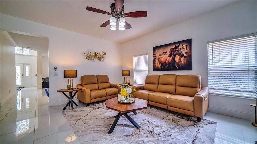 A living room features tan leather furniture, a patterned rug, and a horse wall painting — 6956 LUCCA STREET, ORLANDO, FL