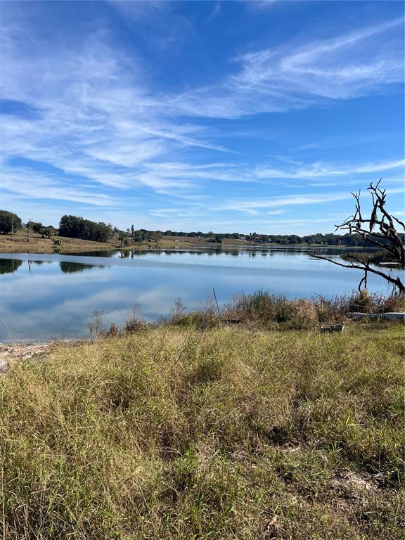 A grassy field overlooks a calm lake under a bright blue sky with wispy clouds — 0 CENTRAL AVENUE, BARTOW, FL