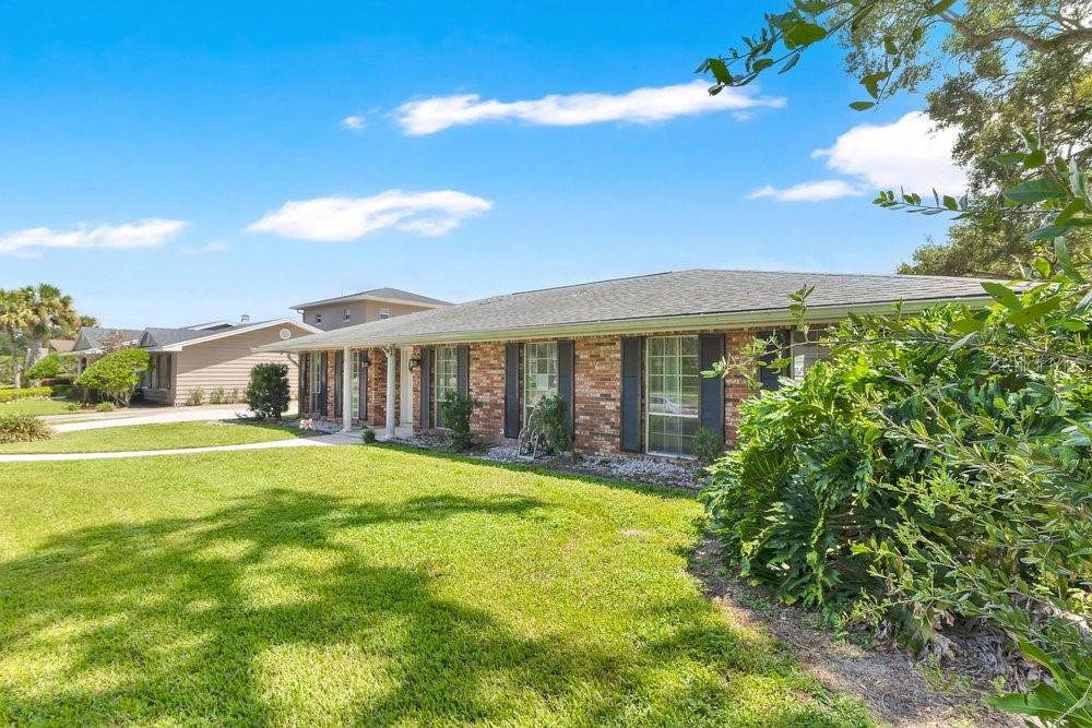A single-story brick house with a shingled roof and a large front lawn — 460 HARBOUR ISLAND ROAD, ORLANDO, FL