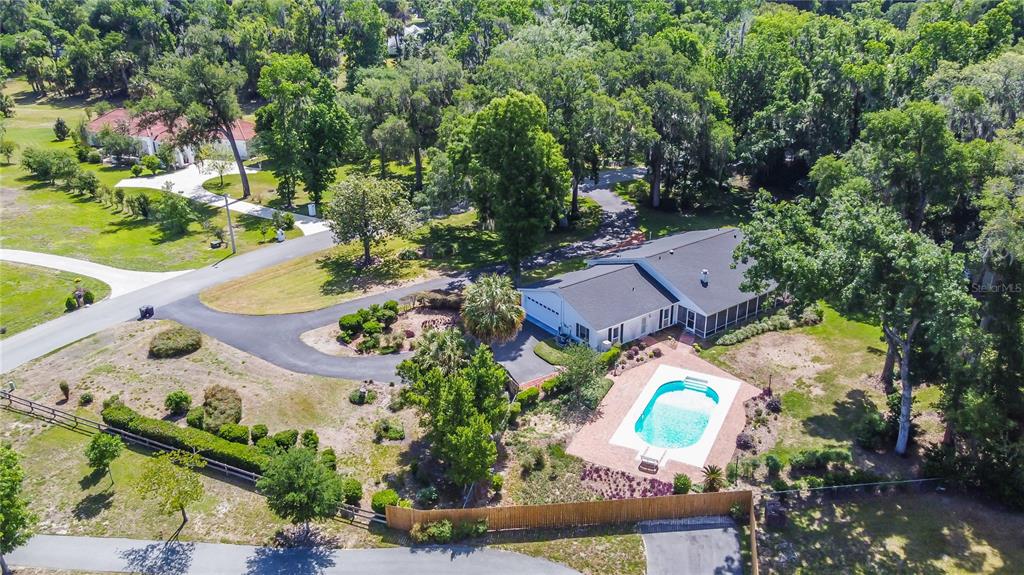 An aerial view shows a house with a swimming pool, driveway, and surrounding wooded yard — 3515 SW 24TH AVENUE ROAD, OCALA, FL