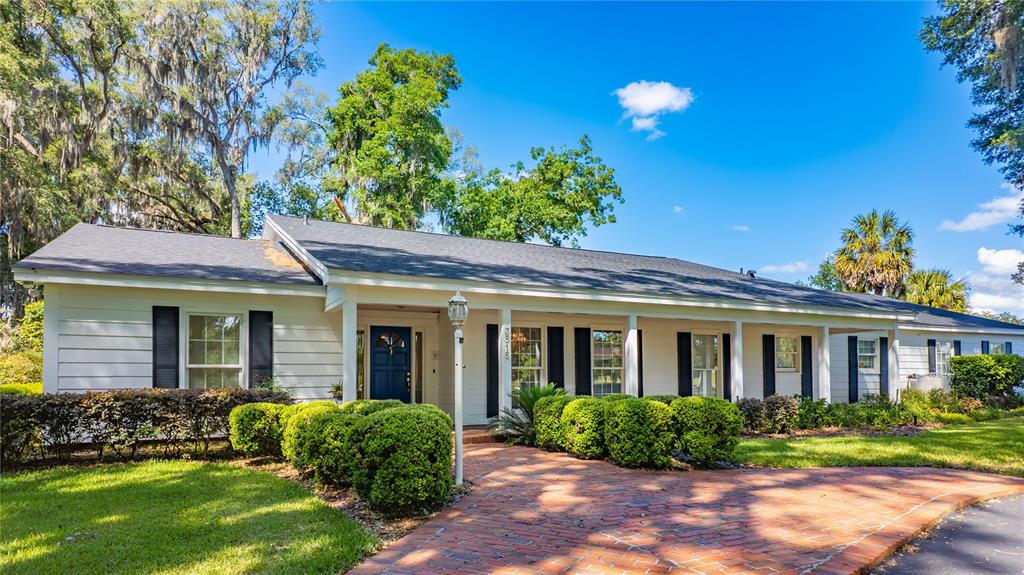 A single-story white house with black shutters and a brick walkway under a blue sky — 3515 SW 24TH AVENUE ROAD, OCALA, FL