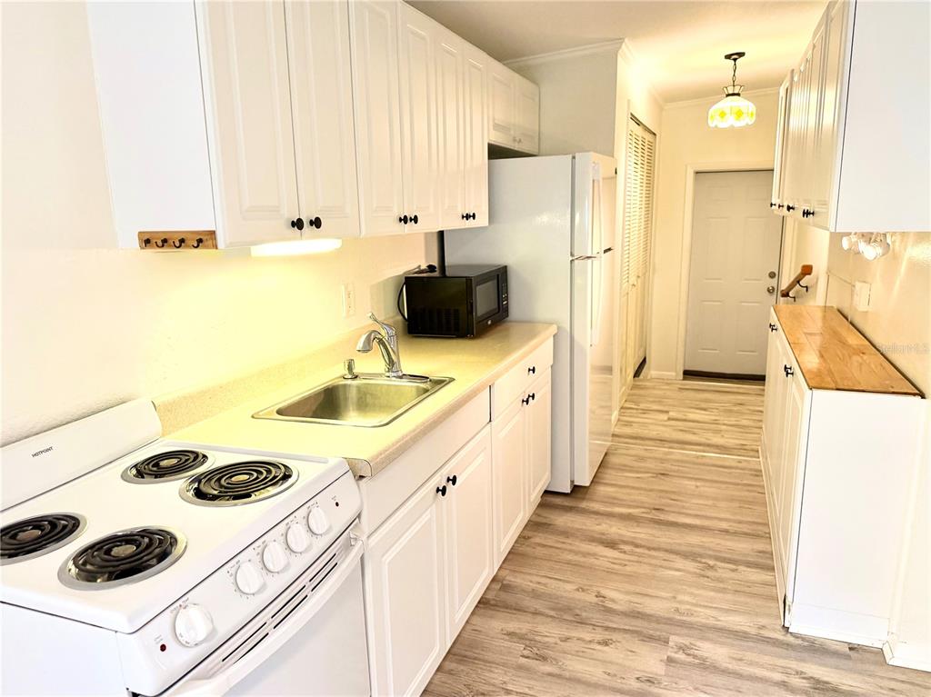 An empty bedroom features light blue walls, hardwood flooring, a ceiling fan, and a window — 516 NORTHMOOR AVENUE N, ST PETERSBURG, FL