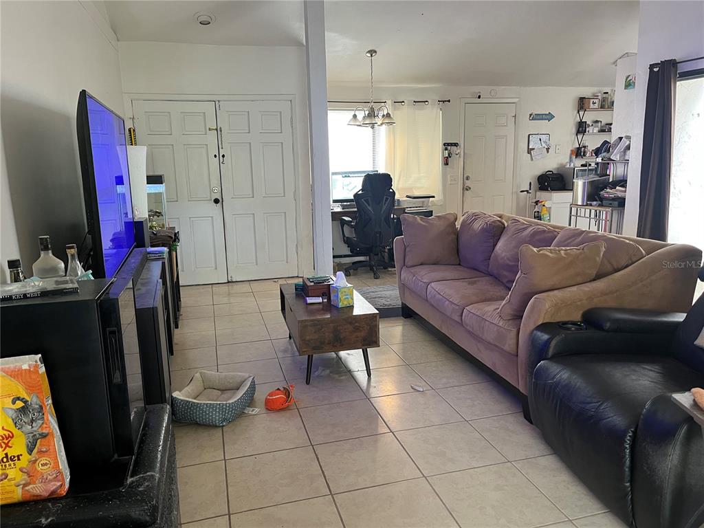 A living room features tile flooring, a large purple sofa, a coffee table, and a television — 12506 FOX CROFT LANE, HUDSON, FL