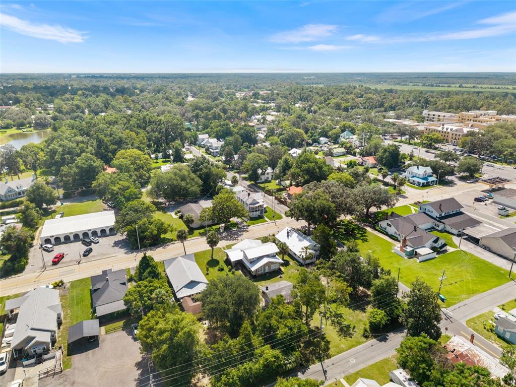 An aerial view shows a residential neighborhood with houses, trees, and a commercial building — 398 S MARION AVENUE, LAKE CITY, FL