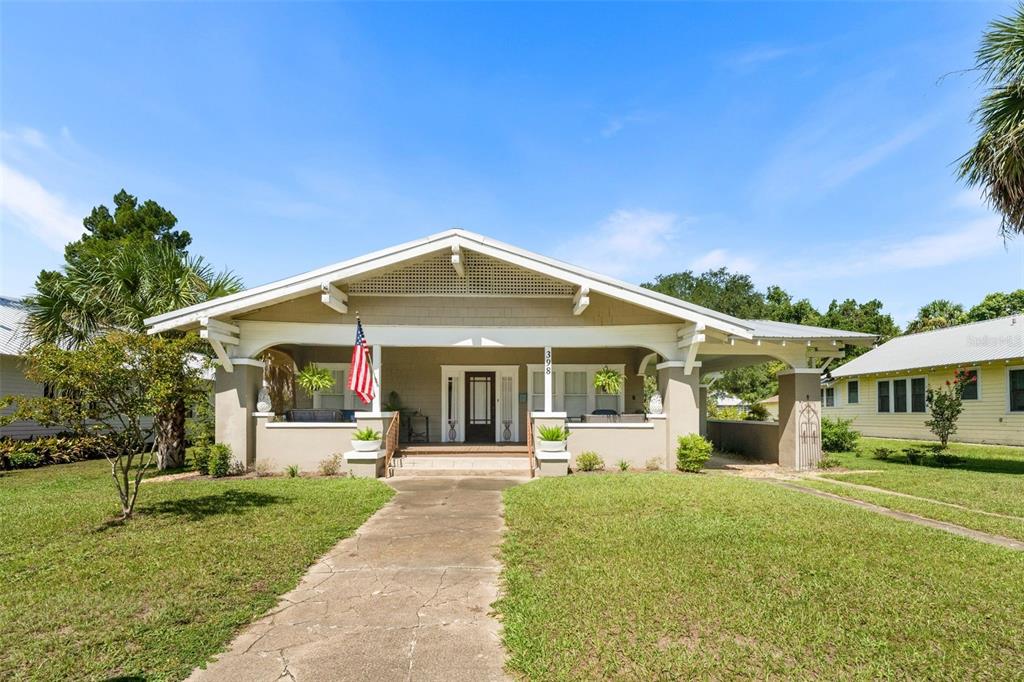 A tan bungalow with a front porch, a gabled roof, and a concrete walkway — 398 S MARION AVENUE, LAKE CITY, FL
