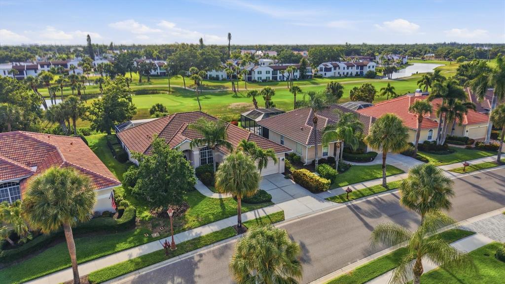 An aerial view of suburban houses with tile roofs, palm trees, and a golf course — 401 MARSH CREEK ROAD, VENICE, FL