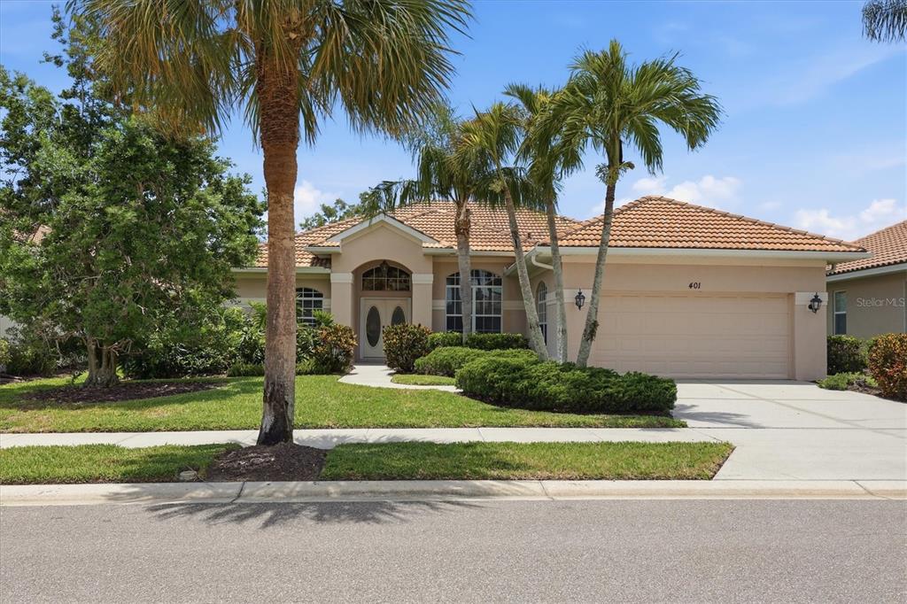 A single-story house with a tiled roof, palm trees, and a two-car garage — 401 MARSH CREEK ROAD, VENICE, FL