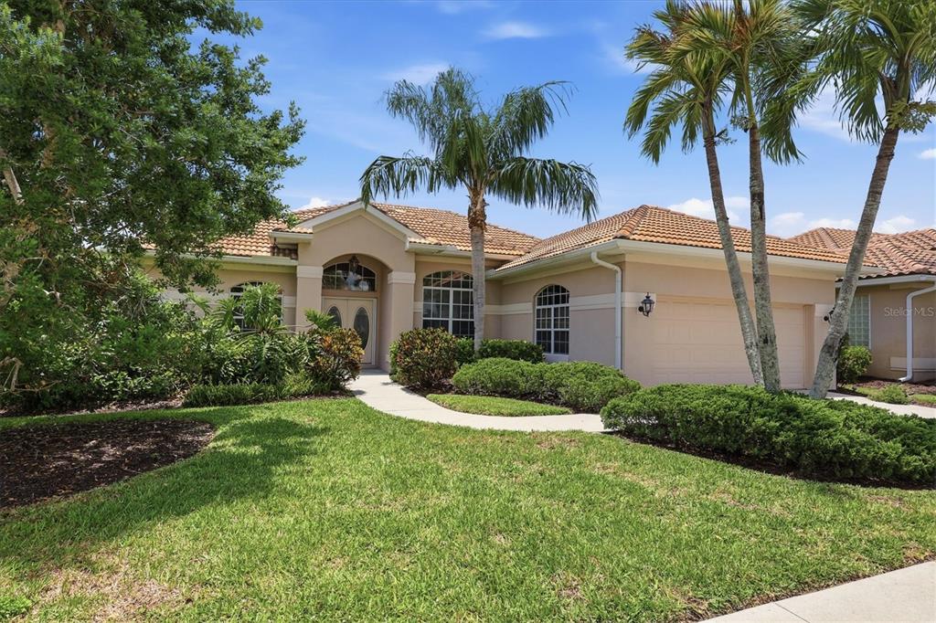 A single-story stucco house with a tile roof, palm trees, and a landscaped front yard — 401 MARSH CREEK ROAD, VENICE, FL
