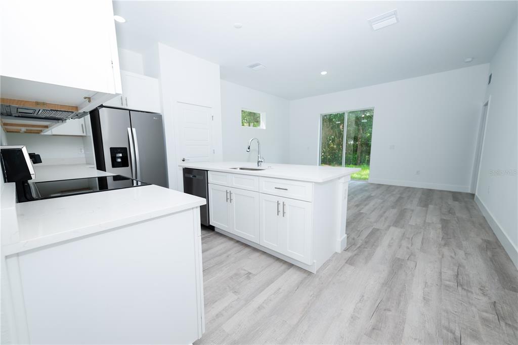 A modern duplex with white stucco walls, gray horizontal siding, and two attached garages — 9298 N MENDOZA WAY, CITRUS SPRINGS, FL