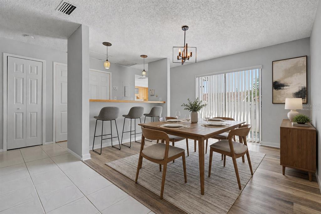 A dining area with a wooden table, chairs, and a breakfast bar with stools — 75 POOLE PLACE, OLDSMAR, FL